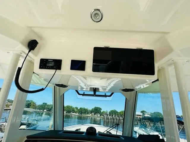 Slide: The Image of 2023 Boston Whaler 360 Outrage helm with electronics and waterfront view. - 23