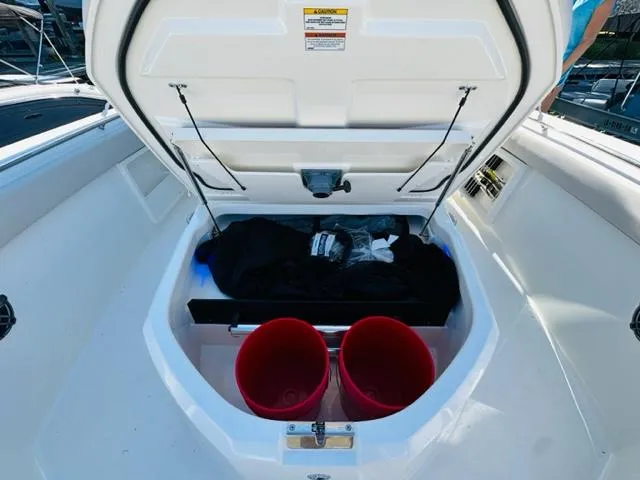 Slide: The Image of Storage compartment of 2023 Boston Whaler 360 Outrage boat with red buckets. - 39