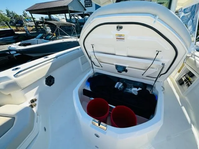 Slide: The Image of 2023 Boston Whaler 360 Outrage storage compartment with open hatch and red buckets. - 40