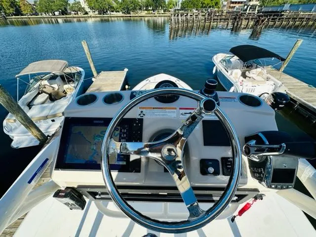 Slide: The Image of Boston Whaler 360 Outrage 2023 helm with navigation system and waterfront view. - 43