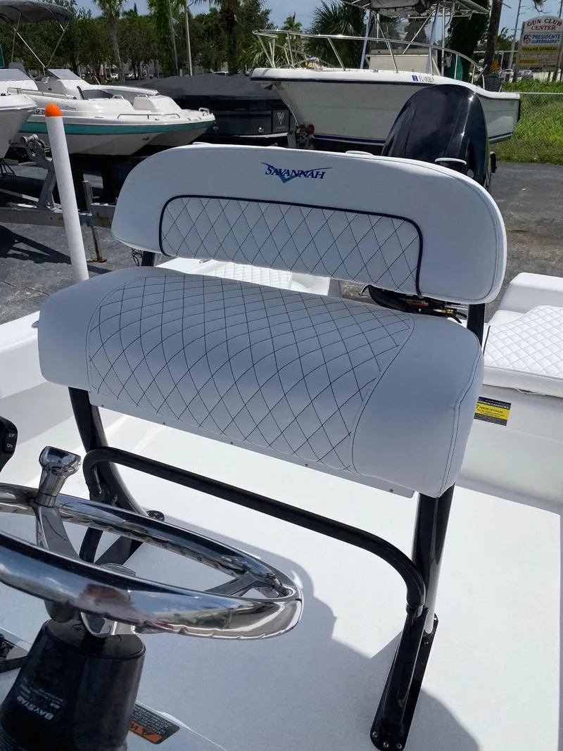 Slide: The Image of 2024 Savannah SS19 boat with white cushioned seating and steering wheel. - 12