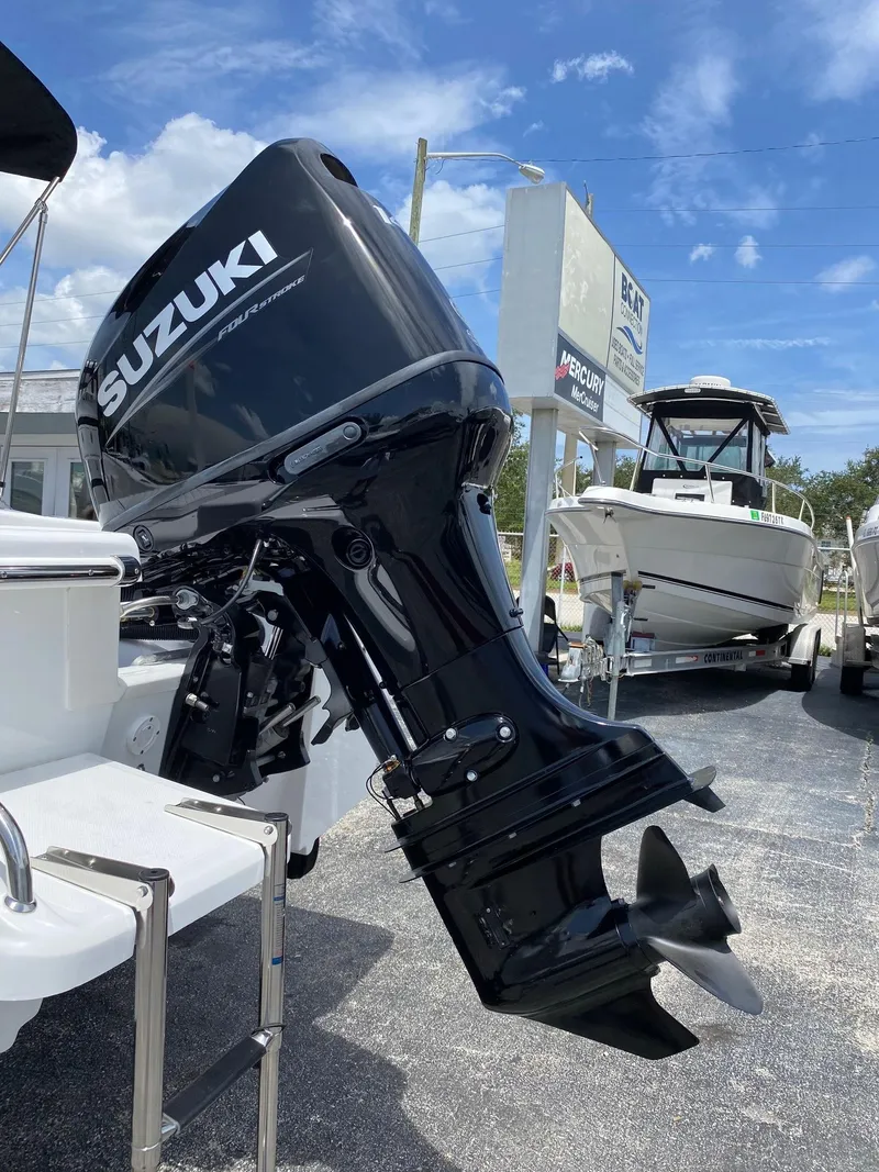 Slide: The Image of 2024 Savannah SS19 boat with Suzuki outboard motor in a dealership lot. - 22