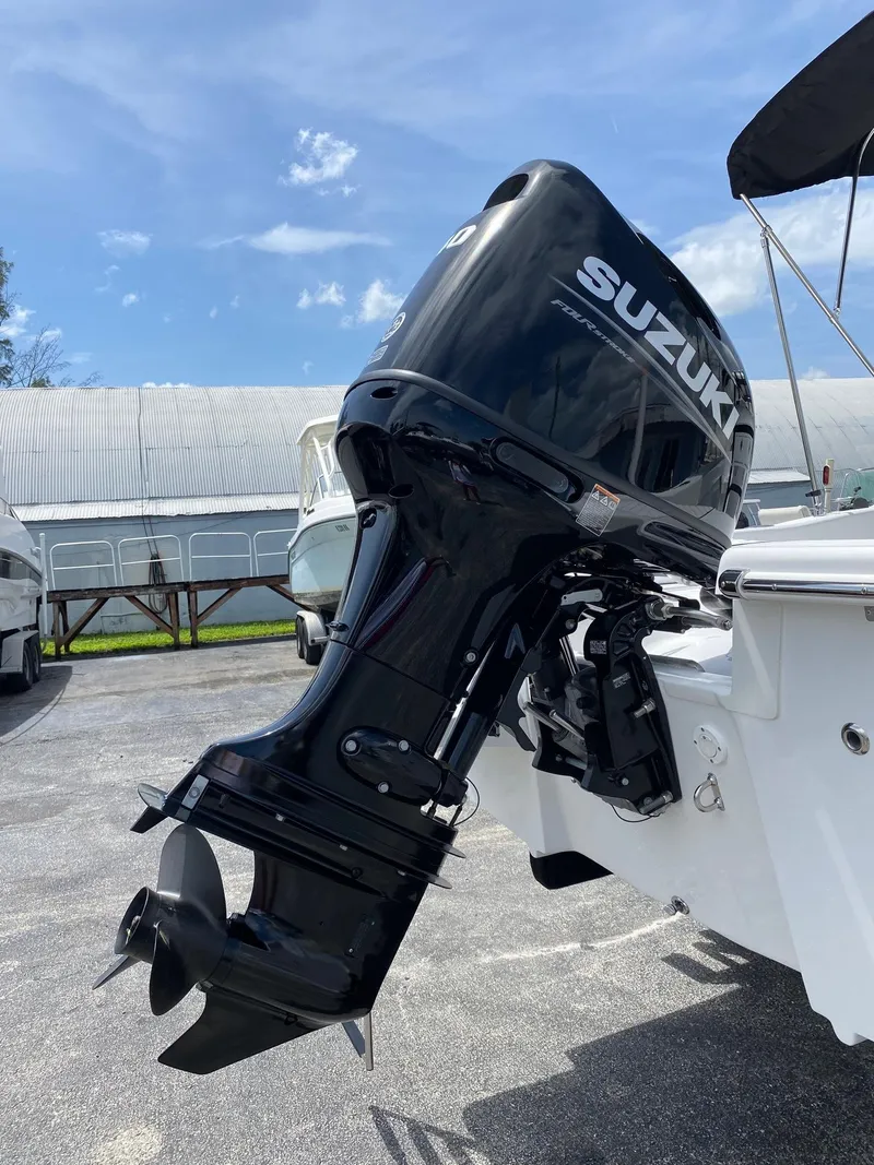 Slide: The Image of 2024 Savannah SS19 boat with Suzuki outboard motor in a marina. - 24
