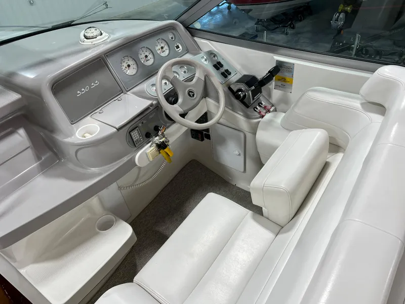 Slide: The Image of 1999 Formula 330 SS Sun Sport boat cockpit with white leather seats and control panel. - 9