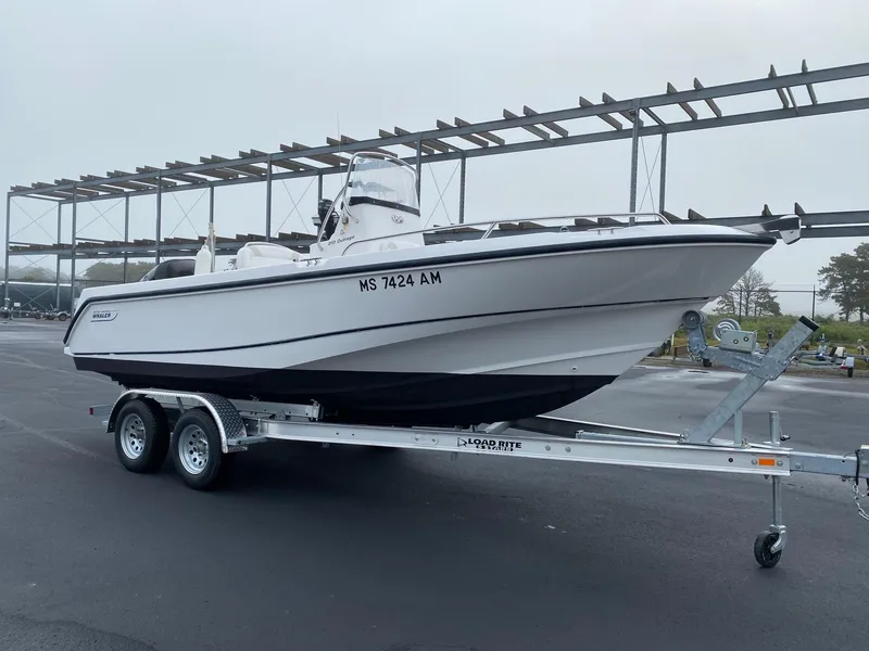 Slide: The Image of 2004 Boston Whaler 210 Outrage boat on a trailer in a parking lot. - 3