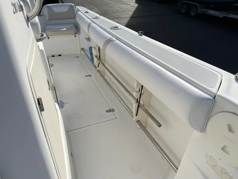 Slide: The Image of 2004 Boston Whaler 210 Outrage boat interior with white seating and storage compartments. - 8