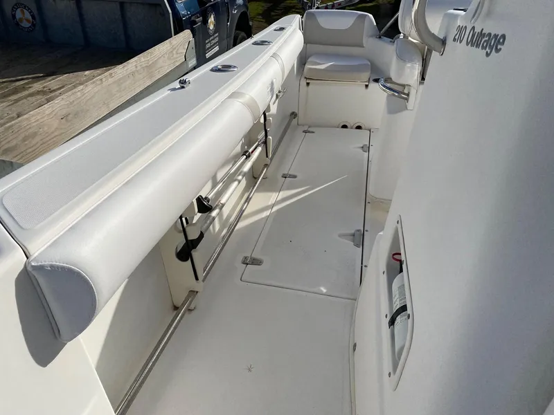 Slide: The Image of 2004 Boston Whaler 210 Outrage boat interior with white seating and storage compartments. - 9