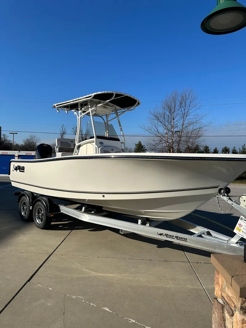 The Image of 2024 Mako 214 CC boat on trailer, parked outdoors under clear blue sky. - 0