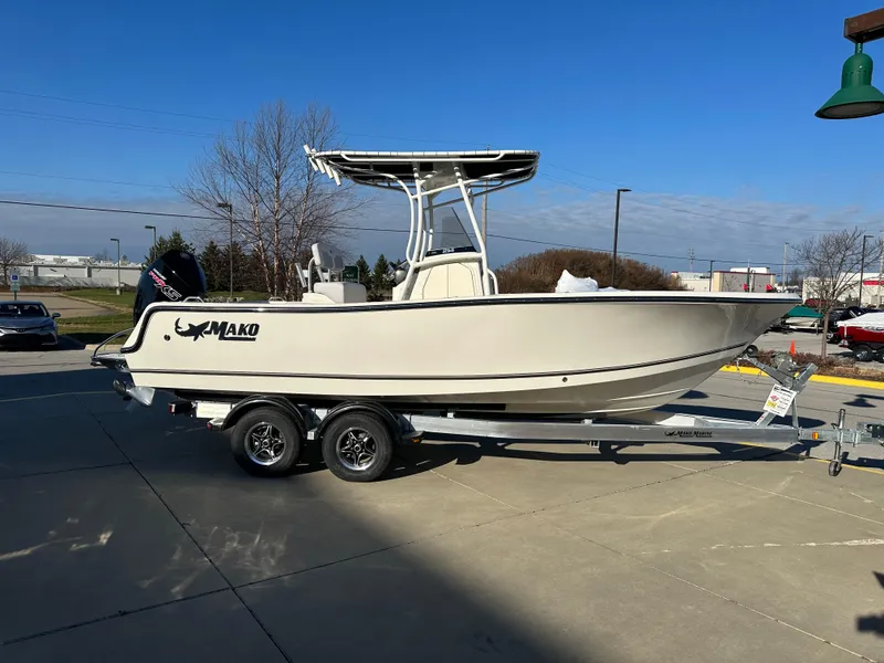 Slide: The Image of 2024 Mako 214 CC boat on trailer, parked outdoors under clear blue sky. - 2
