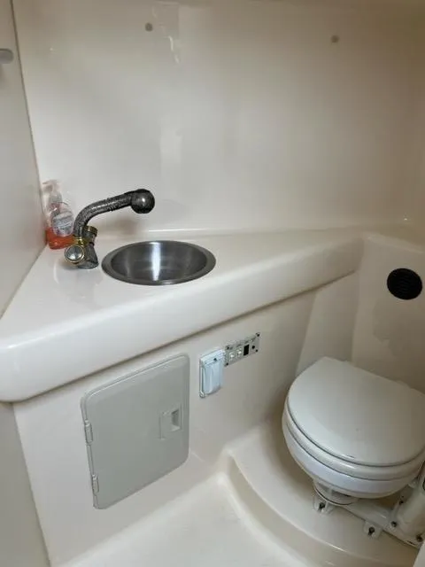 Slide: The Image of 2002 Larson 254 Cabrio boat bathroom with sink and toilet. - 10