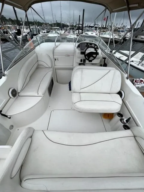 Slide: The Image of 2002 Larson 254 Cabrio boat interior with white seating and steering console. - 4
