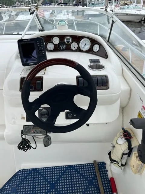 Slide: The Image of 2002 Larson 254 Cabrio boat dashboard with steering wheel and navigation instruments. - 6
