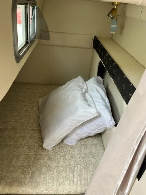 Slide: The Image of 2002 Larson 254 Cabrio cabin interior with bed and pillows. - 7
