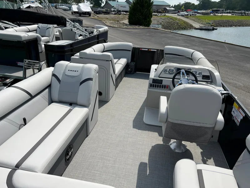 Slide: The Image of 2024 Crest Classic LX 220 pontoon boat with spacious seating and modern helm. - 11
