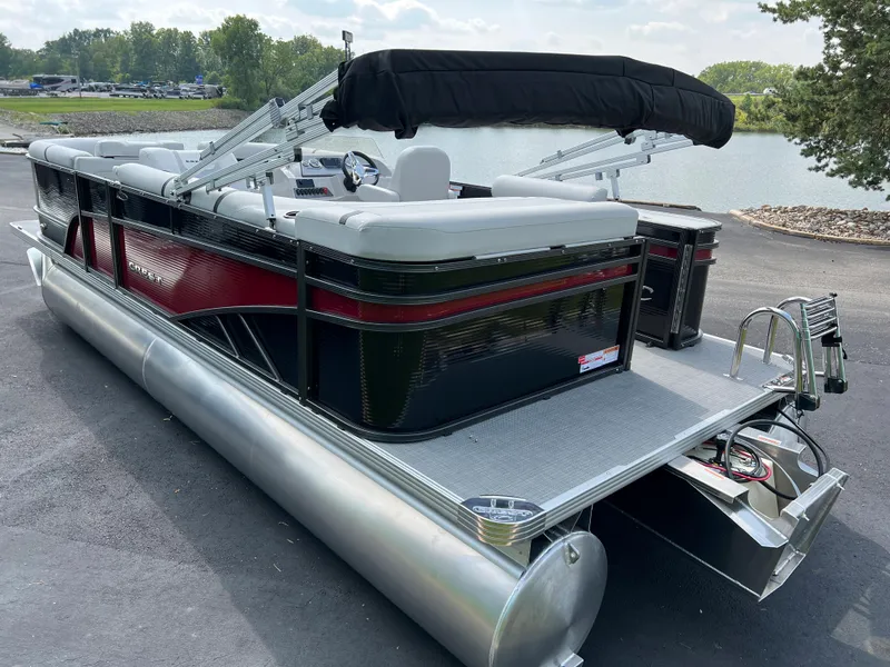 Slide: The Image of 2024 Crest Classic LX 220 pontoon boat docked by a serene lake. - 2