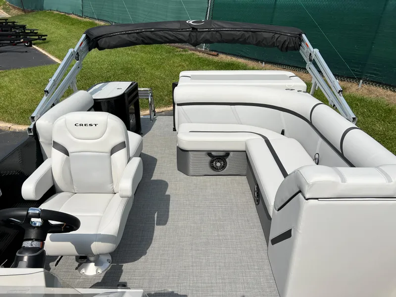 Slide: The Image of 2024 Crest Classic LX 220 pontoon boat interior with white seating and helm. - 8