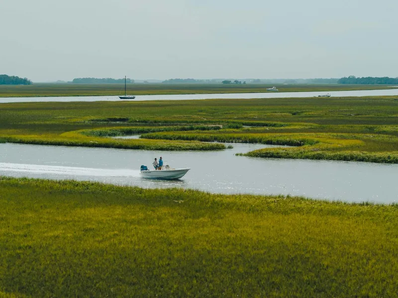 Slide: The Image of 2024 Key West 188 Bay Reef boat cruising through scenic marshland waterways. - 16