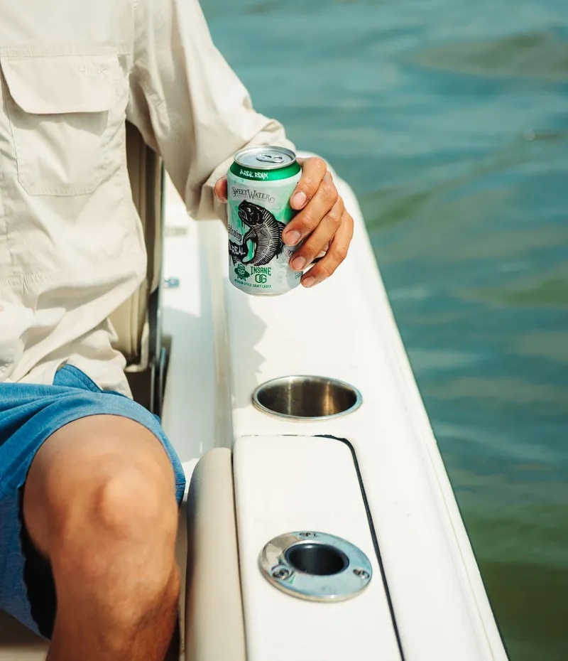 Slide: The Image of Man relaxing on a 2024 Key West 188 Bay Reef boat holding a beverage can. - 25