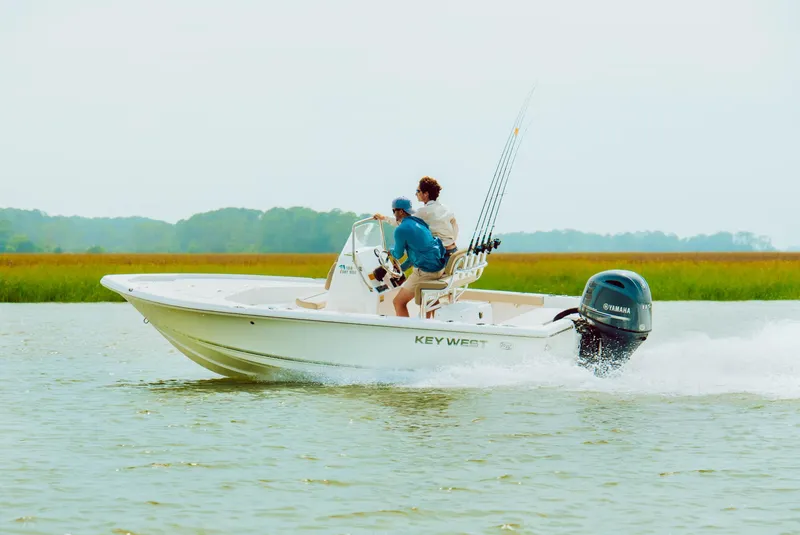 Slide: The Image of 2024 Key West 188 Bay Reef boat cruising on water with two passengers. - 33