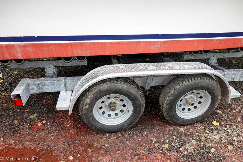 Slide: The Image of Trailer for 2002 Eastern Lobsterman 22 boat with dual wheels on a dirt surface. - 19
