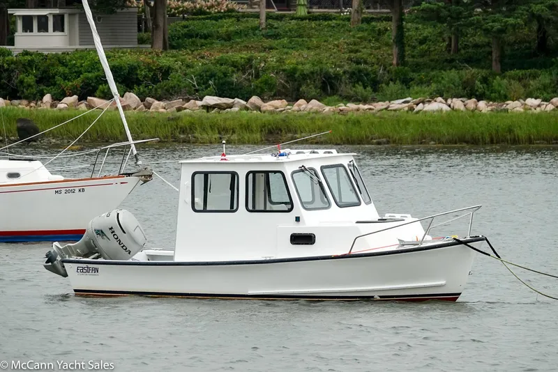 Slide: The Image of 2002 Eastern Lobsterman 22 boat anchored on calm water near a grassy shoreline. - 2