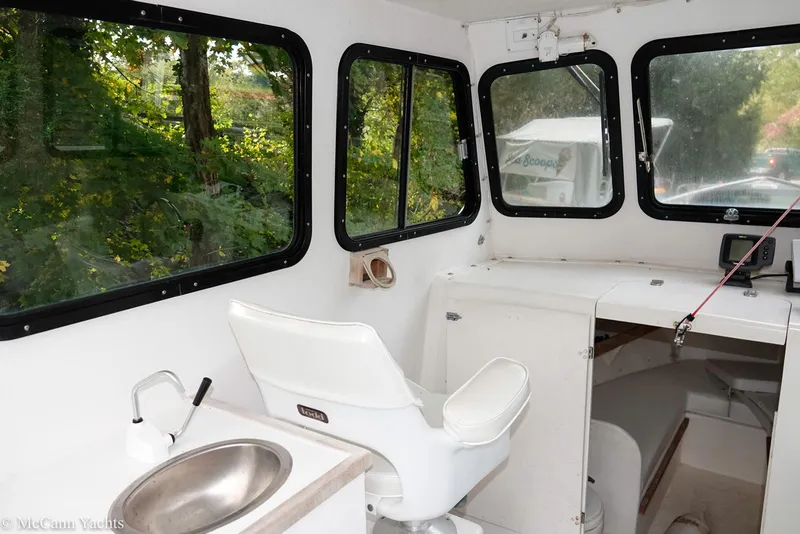 Slide: The Image of Interior of 2002 Eastern Lobsterman 22 boat with white seating and windows. - 24