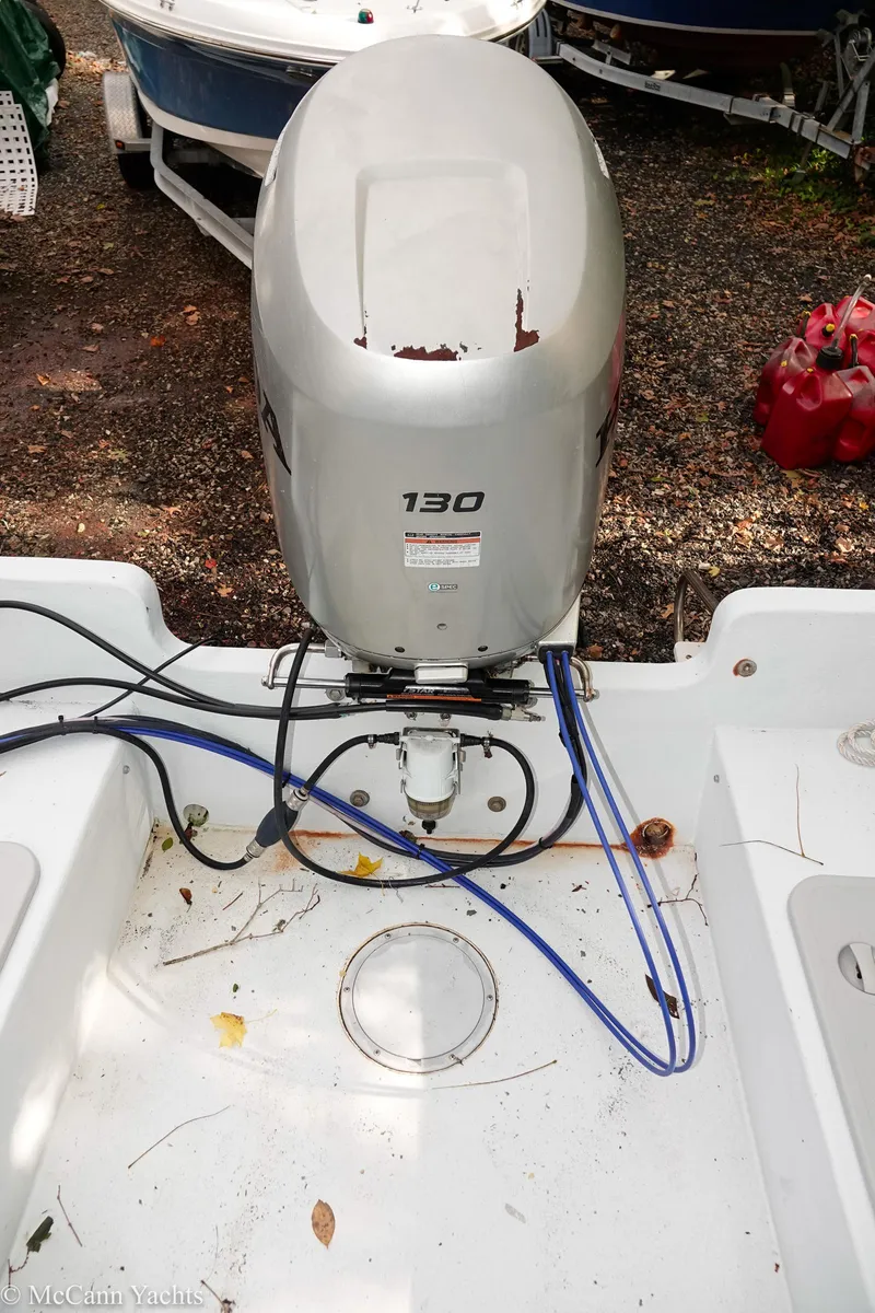 Slide: The Image of Outboard motor on a 2002 Eastern Lobsterman 22 boat, with visible cables and leaves. - 39