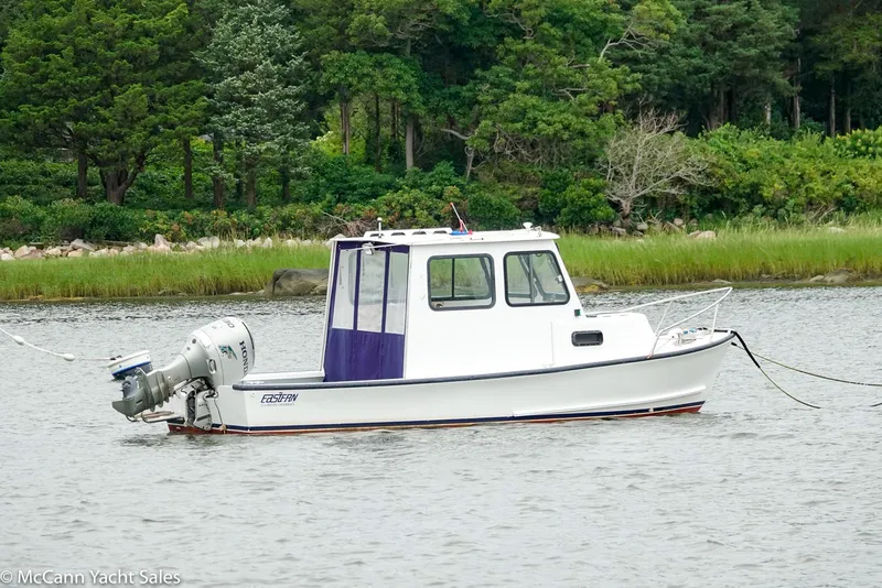 Slide: The Image of 2002 Eastern Lobsterman 22 boat on calm water, surrounded by lush greenery. - 4