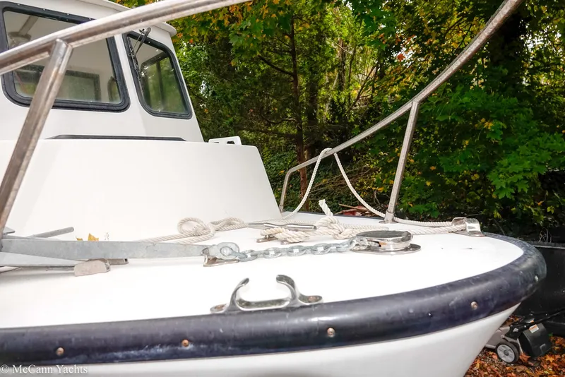 Slide: The Image of 2002 Eastern Lobsterman 22 boat with white deck, surrounded by lush green trees. - 42