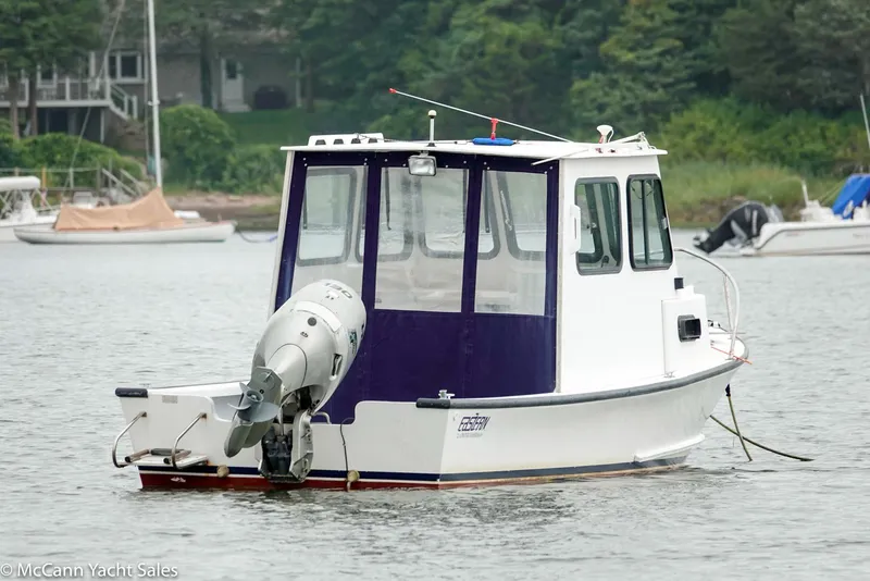 Slide: The Image of 2002 Eastern Lobsterman 22 boat on calm water, with outboard motor and cabin. - 6