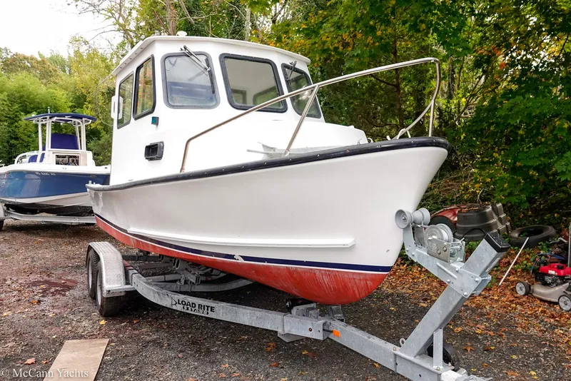 Slide: The Image of 2002 Eastern Lobsterman 22 boat on trailer, white hull, red bottom, parked outdoors. - 15