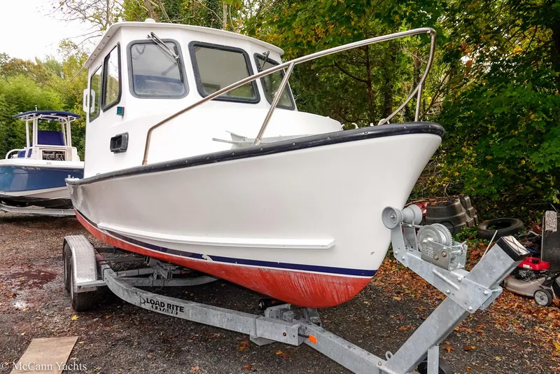 Slide: The Image of 2002 Eastern Lobsterman 22 boat on trailer, white hull, red bottom, parked outdoors. - 17