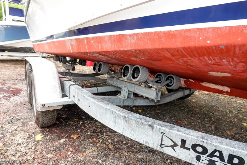 Slide: The Image of Trailer with 2002 Eastern Lobsterman 22 boat, red hull, on gravel surface. - 18