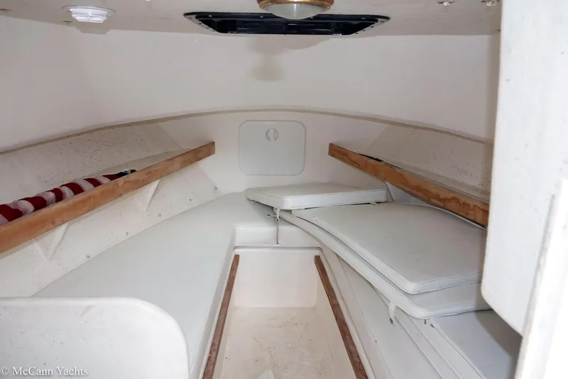 Slide: The Image of 2002 Eastern Lobsterman 22 cabin interior with white cushions and wooden accents. - 26
