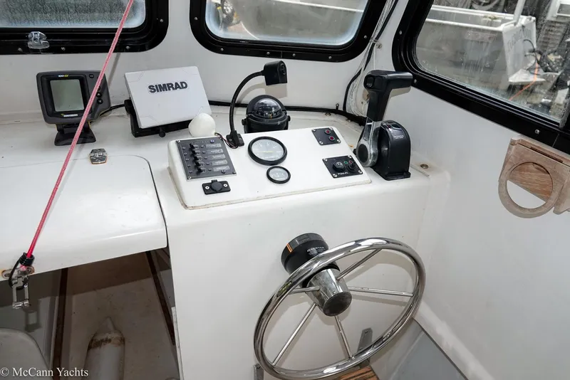 Slide: The Image of 2002 Eastern Lobsterman 22 boat cockpit with steering wheel and navigation controls. - 29