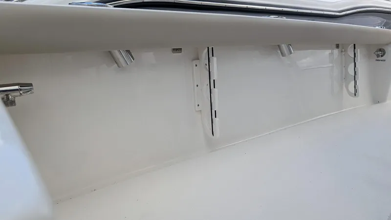 Slide: The Image of 2024 Key West 230 Bay Reef interior detail showing rod holders and storage compartments. - 11