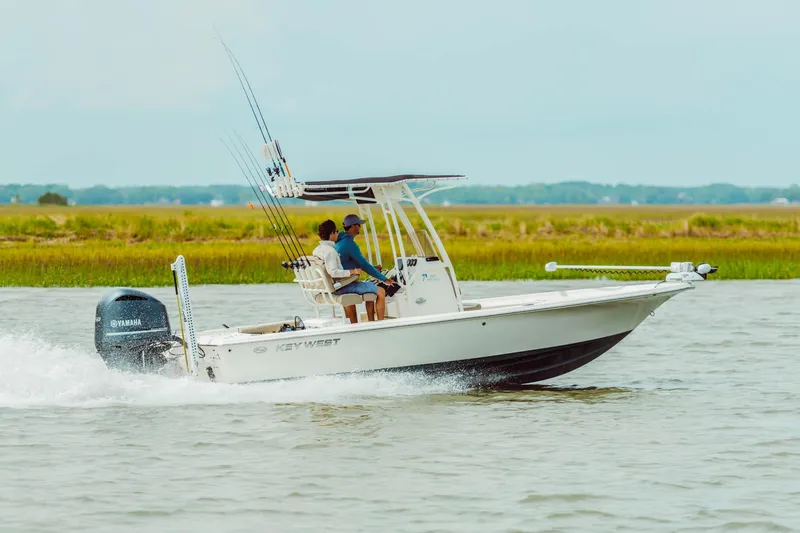 Slide: The Image of 2024 Key West 230 Bay Reef boat cruising on water with two passengers. - 19