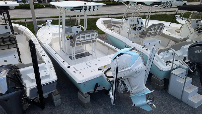 Slide: The Image of 2024 Key West 230 Bay Reef boat displayed in a showroom. - 2