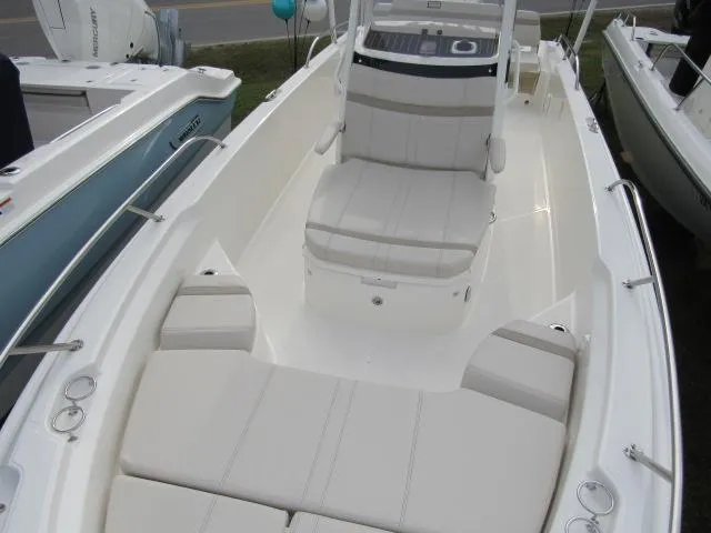 Slide: The Image of 2024 Boston Whaler 250 Dauntless boat interior with cushioned seating and console. - 2