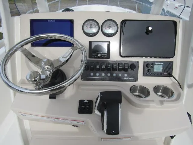 Slide: The Image of 2024 Boston Whaler 250 Dauntless boat console with steering wheel and navigation controls. - 4
