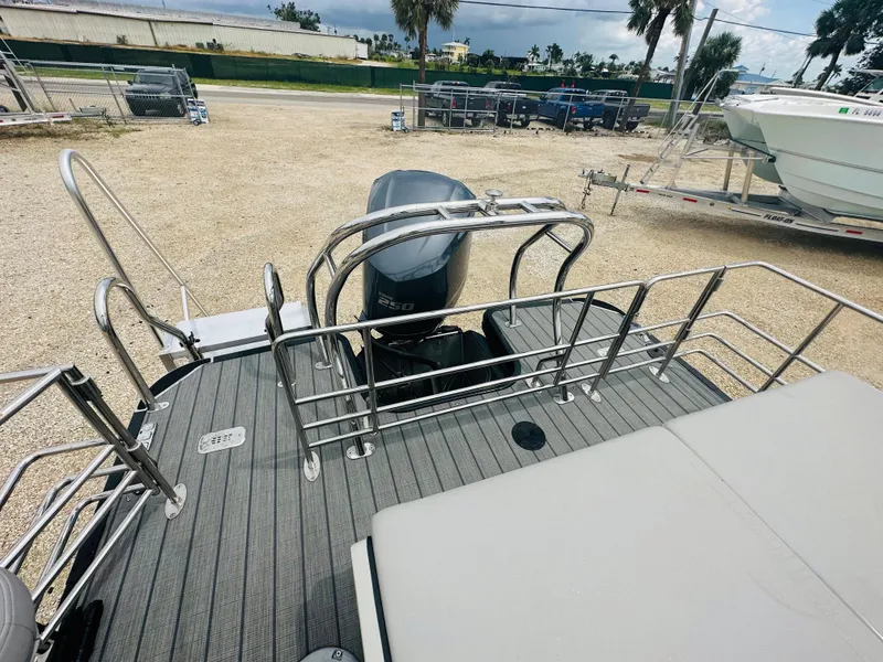 Slide: The Image of 2023 Starcraft CX 23 DL BAR boat storage compartment with cup holders and gray seating. - 16