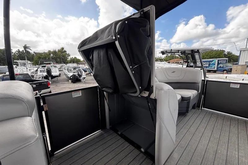 Slide: The Image of 2023 Starcraft CX 23 DL BAR boat interior with seating and storage, docked outdoors. - 24
