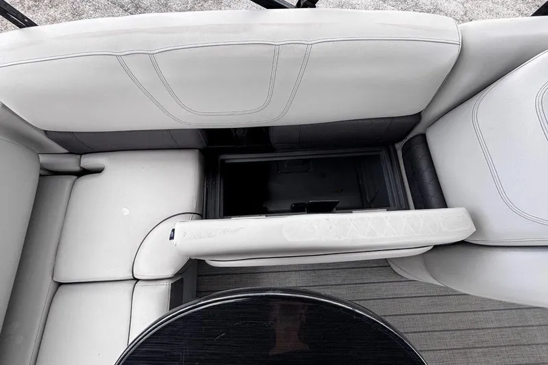 Slide: The Image of 2023 Starcraft CX 23 DL BAR boat interior with white cushioned seating and storage compartment. - 37