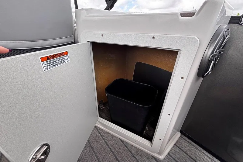 Slide: The Image of 2023 Starcraft CX 23 DL BAR storage compartment with open door and black bin inside. - 41