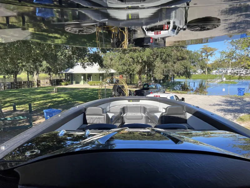 Slide: The Image of 2023 Mystic Powerboats M4200 at a lakeside park with trees and a house. - 11