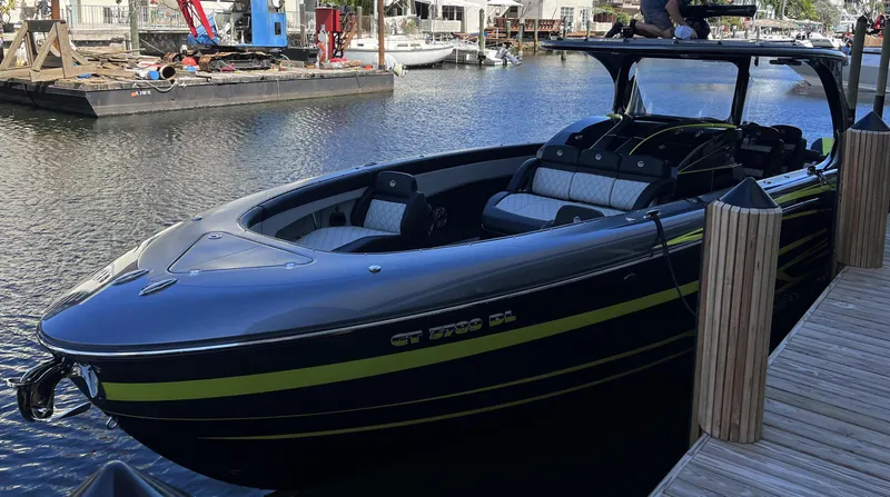 Slide: The Image of 2023 Mystic Powerboats M4200 docked at marina, sleek black and yellow design. - 12