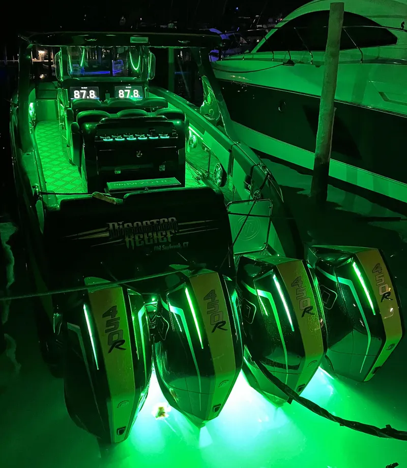 Slide: The Image of 2023 Mystic Powerboats M4200 illuminated at night with green LED lights. - 16