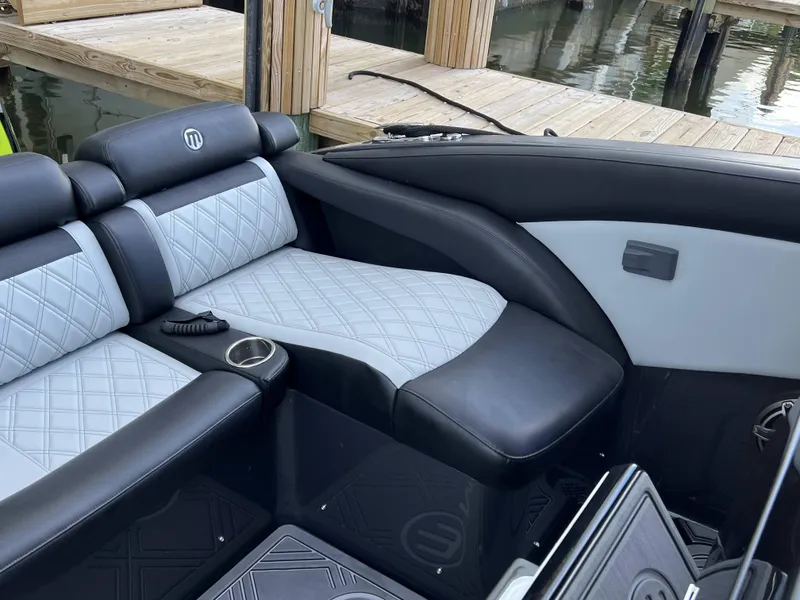 Slide: The Image of 2023 Mystic Powerboats M4200 interior seating with diamond-stitched upholstery and cup holder. - 8