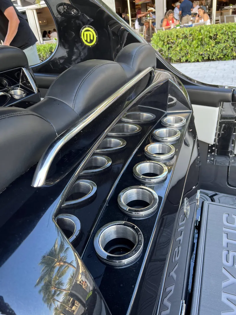 Slide: The Image of 2023 Mystic Powerboats M4200 interior with multiple cup holders and sleek black design. - 9