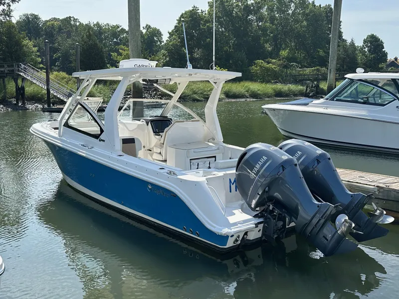 Slide: The Image of 2018 Edgewater 262CX boat with twin Yamaha engines docked in a marina. - 0